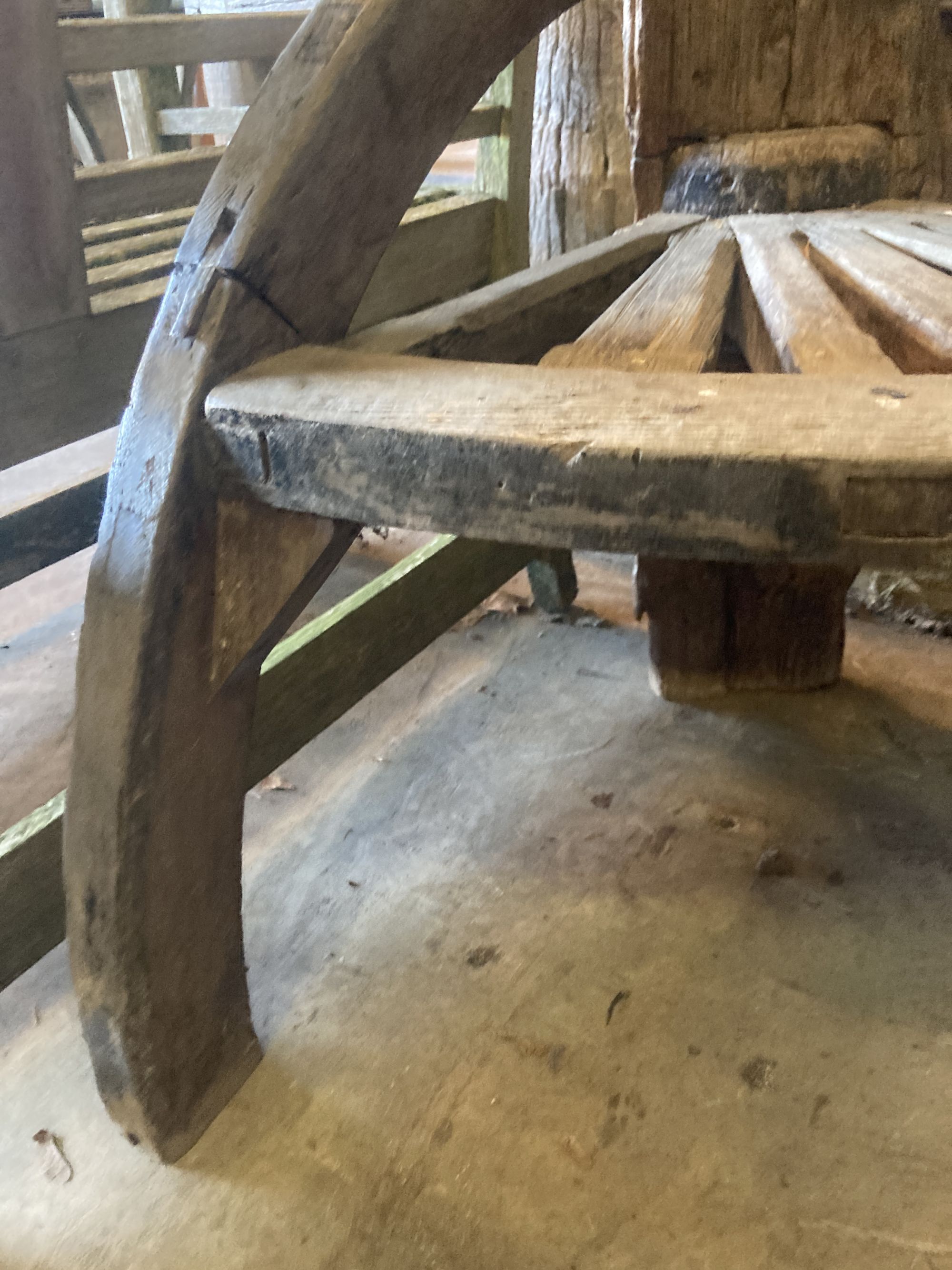 A weathered hardwood cartwheel and reclaimed timber garden seat, width 88cm depth 70cm height 170cm